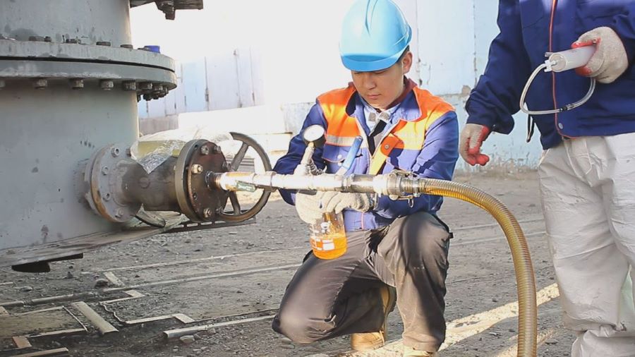 Engineer collecting oil for oil sample