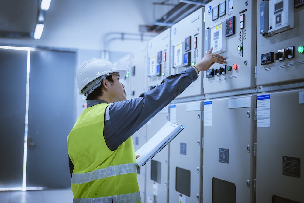 Engineer pointing at switchroom electric panel